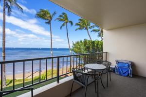 a balcony with a table and chairs and the beach at SUGAR BEACH RESORT, #235 in Kihei