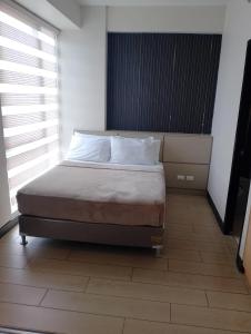 a bedroom with a bed with white pillows on it at Condo in Mactan Newtown in Lapu Lapu City +2 photos