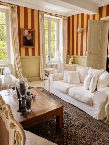 a living room with a white couch and a table at Château de Lavail in Labastide-dʼAnjou