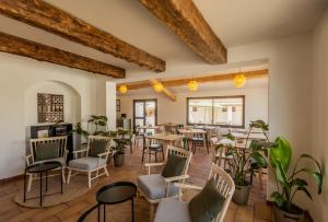 a restaurant with tables and chairs and plants at L'Oustau des Palunettes Concept Adulte only in Saintes-Maries-de-la-Mer
