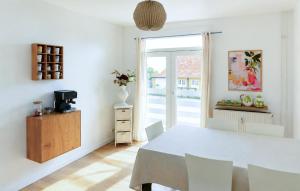 a white dining room with a white table and chairs at Casa Blanca in Gudhjem