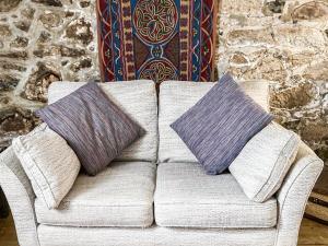 two pillows sitting on a couch in a room at Driftwood in St Ives +2 photos