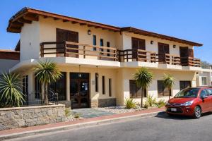a red car parked in front of a house at Hotel Gran Lucerna in Valle Hermoso