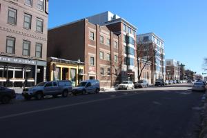 a city street with cars parked on the side of the road at West Broadway Quarters by Thatch in Boston