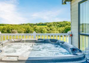a jacuzzi tub on the back of a house at Meadow Lakes Holiday Park in St Austell