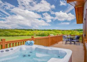 a jacuzzi tub on the deck of a house at Meadow Lakes Holiday Park in St Austell