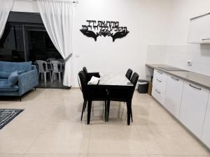 a kitchen and dining room with a table and chairs at הפינה של פנינה במושבה - דירה משפחתית מהממת in Migdal +8 photos