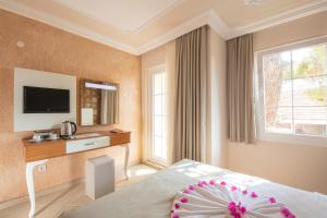 a hotel room with a bed and a television at Nicholas Park Hotel in Oludeniz