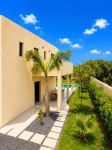 a house with palm trees in front of it at Villa Elysia in Ech Chaïbat