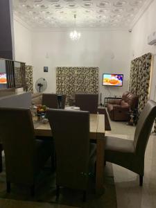 a dining room with a table and chairs and a couch at FREDJACKSAIR BnB in Koforidua