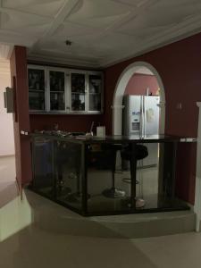 a kitchen with a glass counter with a refrigerator at FREDJACKSAIR BnB in Koforidua