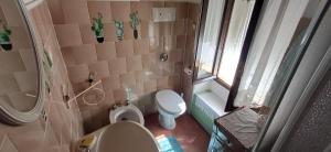 a small bathroom with a toilet and a window at Nespello Tourist Accommodation in Costa di Serina +3 photos