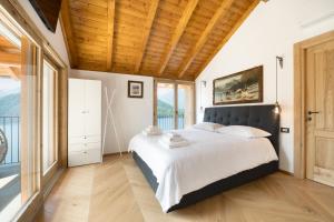 a bedroom with a large bed with a wooden ceiling at Perla di Mergozzo 1 in Mergozzo
