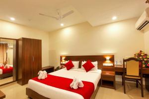 a hotel room with a large bed and a desk at Chandni Park in Ernakulam
