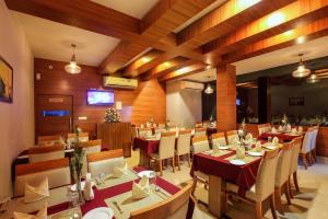 a restaurant with tables and chairs in a room at Chandni Park in Ernakulam