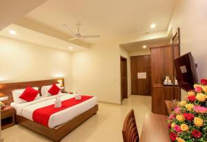 a bedroom with a bed and a table and a television at Chandni Park in Ernakulam