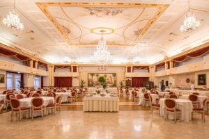 ein Festsaal mit Tischen und Stühlen und einem Kronleuchter in der Unterkunft Baglio Basile - CDSHotels in Petrosino + 67 Fotos