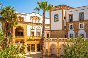 ein gelbes Gebäude mit Palmen davor in der Unterkunft Baglio Basile - CDSHotels in Petrosino