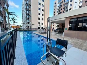 a chair sitting next to a swimming pool at Lunar Lua Nova 06 in Aracaju