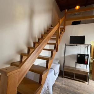 a wooden staircase in a room with a tv at Pousada Ágape in Chapada dos Guimarães