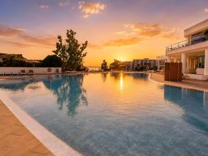 a large swimming pool with a sunset in the background at Dream Ocean Sunset in Playa Paraiso