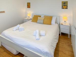 a bedroom with a white bed with towels on it at The Lookout in Sennen