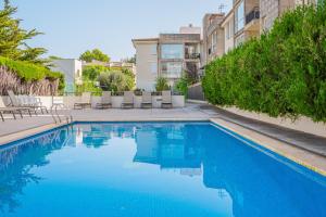 a swimming pool with blue water in a building at Apartamento Llenaire cerca playa in Port de Pollensa