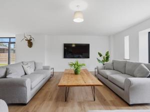 a living room with two couches and a coffee table at Partridge Barn - Uk52217 in Corton