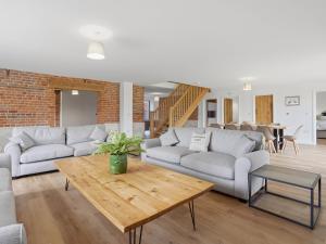 a living room with couches and a wooden table at Partridge Barn - Uk52217 in Corton