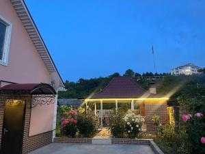 a house with a porch with lights on it at Gusar bungalow in Qusar