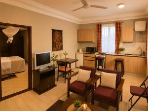 a living room with a television and a kitchen at Roc Heights in Bakau