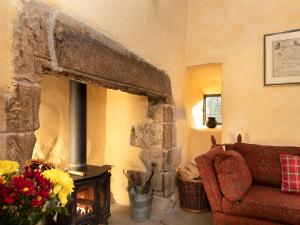 a living room with a stone fireplace and a red couch at Braidwood Castle - Uk10672 in Braidwood