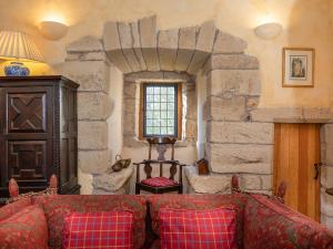 a living room with a couch and a stone wall at Braidwood Castle - Uk10672 in Braidwood