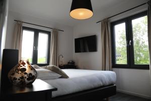 a bedroom with a bed with a vase on a table at Hôtel Restaurant Lamy in Troisvierges