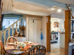 a dining room with a table and a kitchen at Hoopers Farmhouse - Uk36307 in Tilshead