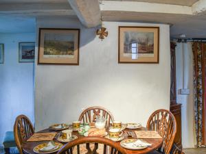 a wooden table with chairs and plates and cups on it at Hoopers Farmhouse - Uk36307 in Tilshead