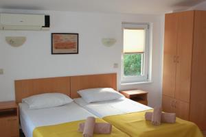 ein Schlafzimmer mit zwei Betten und einem Fenster in der Unterkunft Hotel Radik in Sozopol