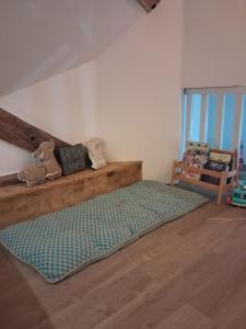 a bedroom with a bed with a green rug on the floor at La grange famille in Tournans