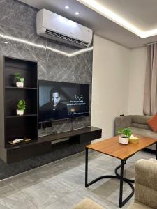 a living room with a flat screen tv on a wall at شقق كالم للشقق المخدومة 1 in Riyadh