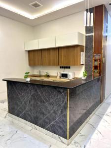 a kitchen with a black counter top and wooden cabinets at شقق كالم للشقق المخدومة 1 in Riyadh