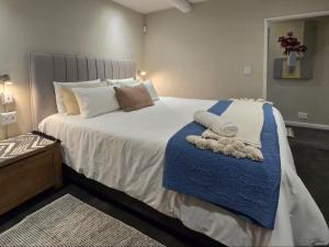 a bedroom with a large bed with a blue blanket at Eternal @ Yzerfontein in Yzerfontein