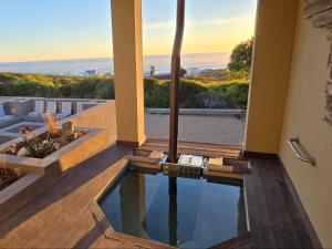 a house with a swimming pool with a view of the ocean at Eternal @ Yzerfontein in Yzerfontein