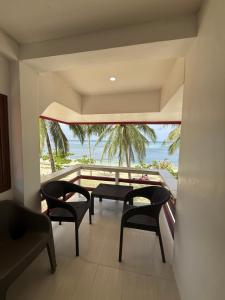 a balcony with chairs and a table and a view of the ocean at Villa Virtud Beach Resort in Alegria +22 photos
