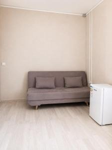 a couch in the corner of a room with a refrigerator at Terra Hotel in Berezovka