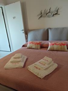 a bed with two folded towels on top of it at Flamingo View apartment in Orbetello