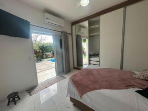 a bedroom with a large bed and a sliding glass door at refúgio urbano in Nova Odessa +40 photos