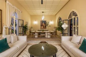 a living room with two couches and a table at Traditional Villa Dar Izza - 4 suite with breakfast in Douar Soukkane