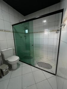 a bathroom with a glass shower and a toilet at Suite Master Casa Luz in Garanhuns +3 photos