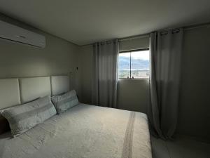 a bedroom with a large bed with a window at Suite Master Casa Luz in Garanhuns
