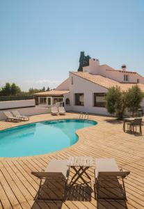 a swimming pool with chairs and a house at L'Oustau des Palunettes Concept Adulte only in Saintes-Maries-de-la-Mer